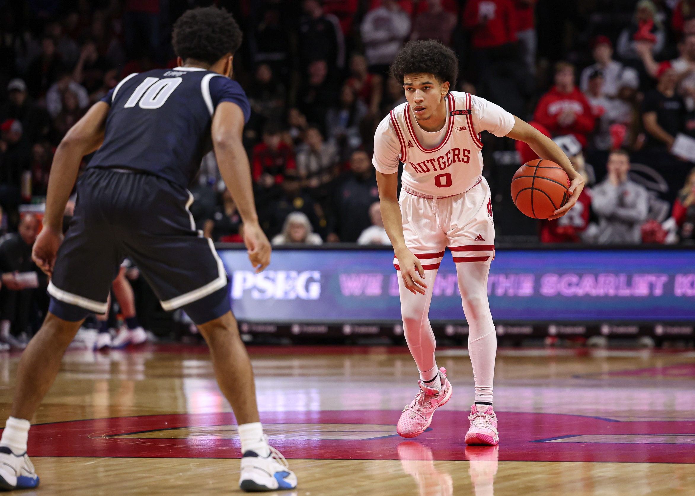 Rutgers Scarlet Knights guard Derek Simpson (0) dribbles as Georgetown Hoyas guard Jayden Epps (10) defends during the second half at Jersey Mike's Arena.